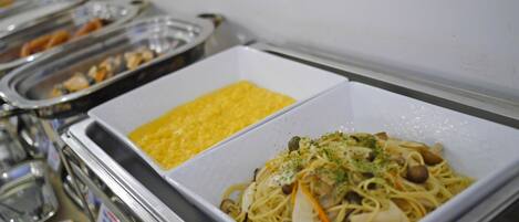 A buffet with pasta and scrambled eggs.