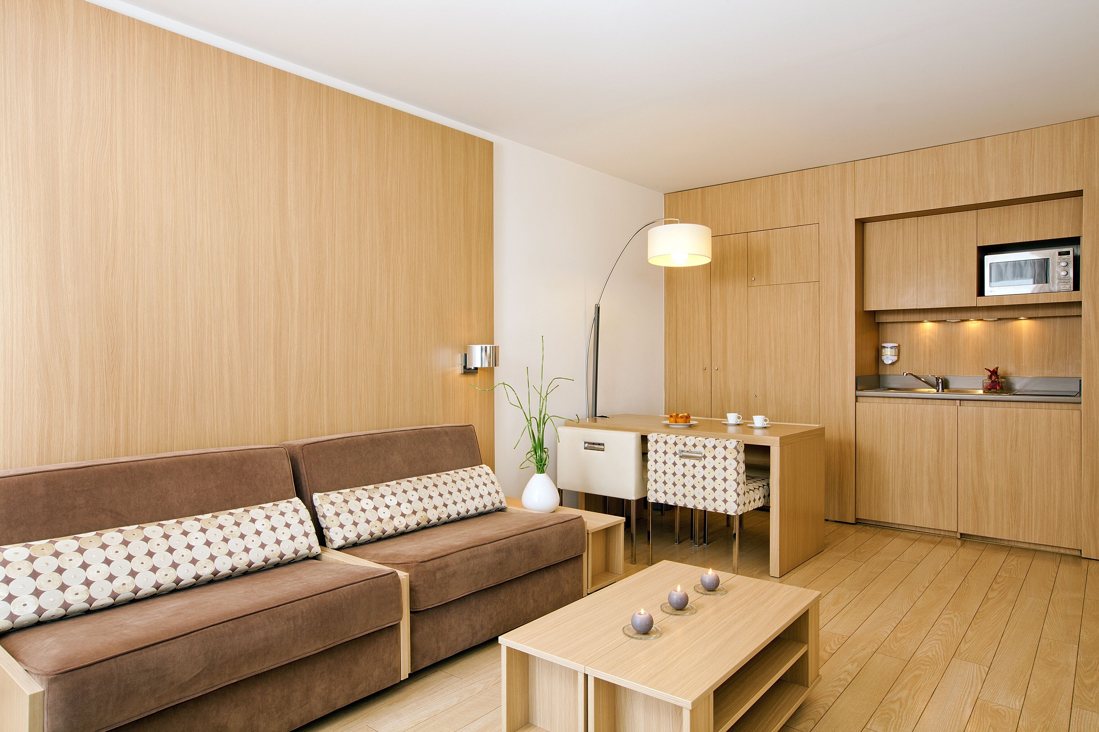 Una sala de estar moderna con un sofá, una mesa de centro y un comedor con una pequeña mesa y sillas.