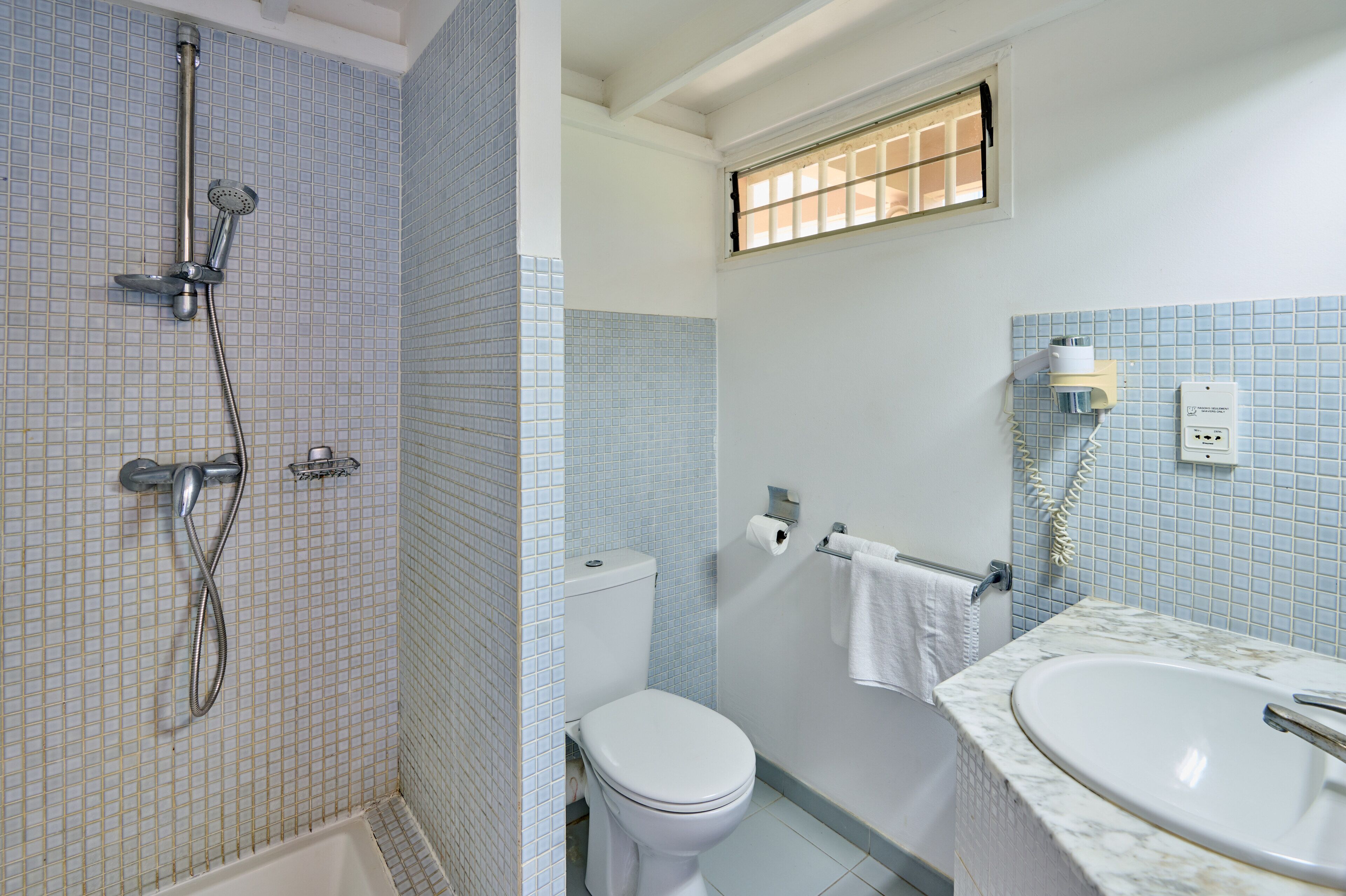 A bathroom with a shower, toilet, and sink.