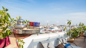 A tray with a teapot and cups on a rooftop terrace with city views. - Dar El Kébira (Rabat)