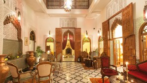 A traditional Moroccan interior with ornate wooden doors, patterned tiles, and classic furniture. - Dar El Kébira (Rabat)