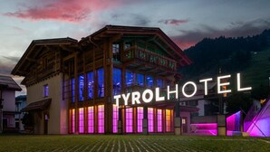 A hotel with a prominent sign, a balcony, and a well-maintained lawn. - Raffl´s Tyrol Hotel (Sankt Anton am Arlberg)