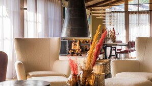 A cozy seating area with a fireplace, comfortable sofas, and a table with decorative vases. - Raffl´s Tyrol Hotel (Sankt Anton am Arlberg)