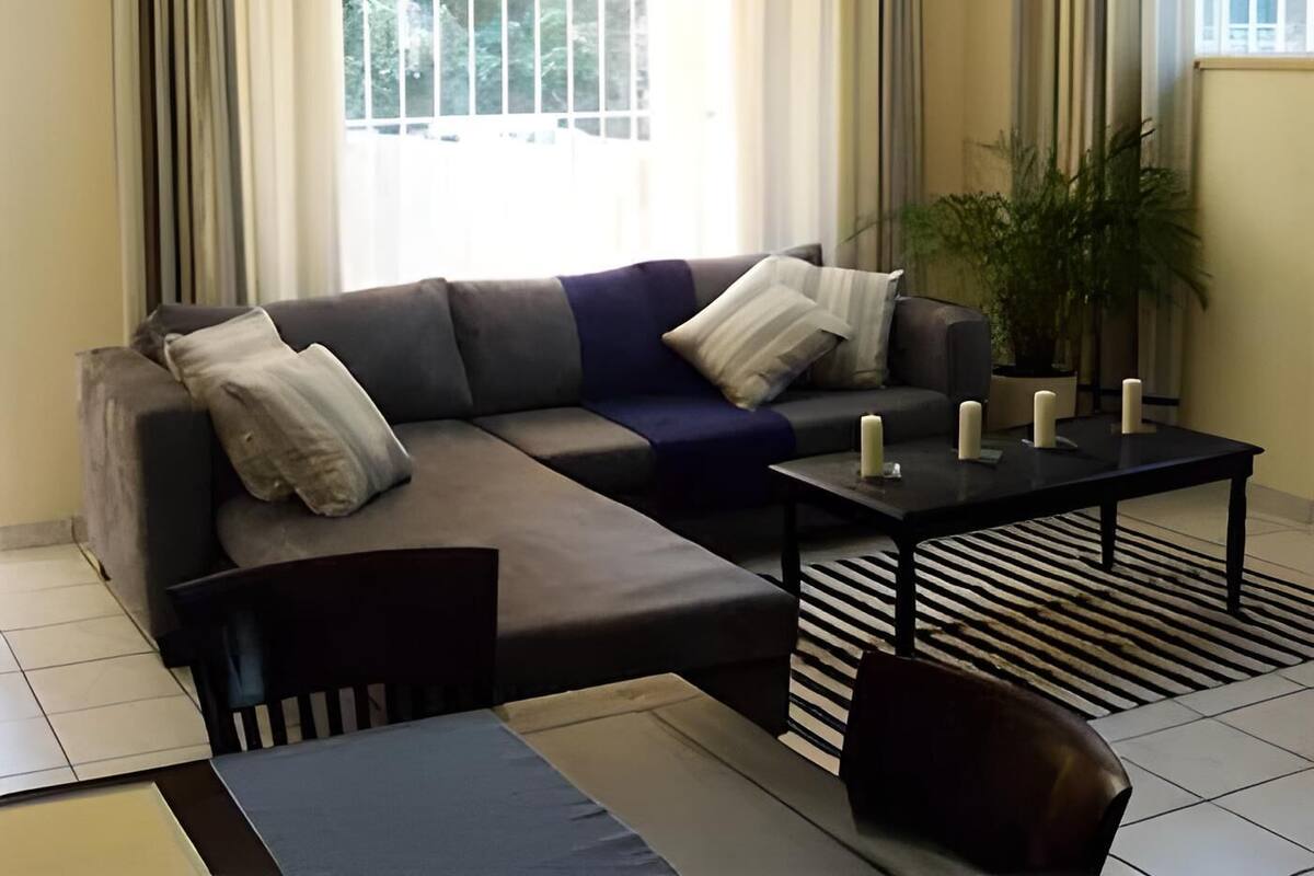 Een moderne woonkamer met een modulaire bank, een salontafel en een gestreept vloerkleed.