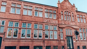 A red brick building with multiple windows and a black door. - Malacuna Birmingham (Birmingham)