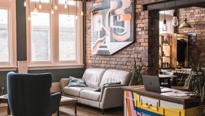 A cozy living room with a sofa, a desk with a laptop, and a colorful cabinet. - Malacuna Birmingham (Birmingham)