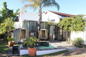 Een buitenzwembad, parasols bij het zwembad en ligstoelen