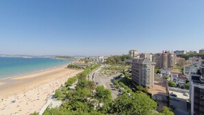 A coastal cityscape with a beach, buildings, and a clear sky. - Hotel Boutique Las Brisas (Santander)