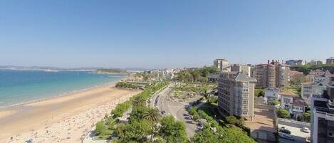 Un paisaje urbano costero con playa, edificios y cielo despejado.