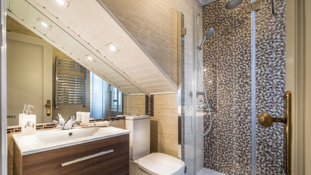 A modern bathroom with a large sink, dark wood vanity, a toilet, and a glass-enclosed shower. - Hotel Boutique Las Brisas (Santander)