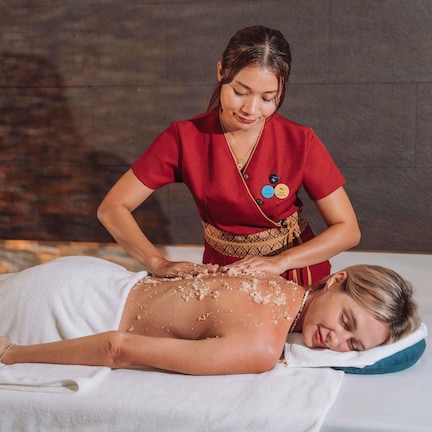 A massage therapy session in a room with a brick wall background.