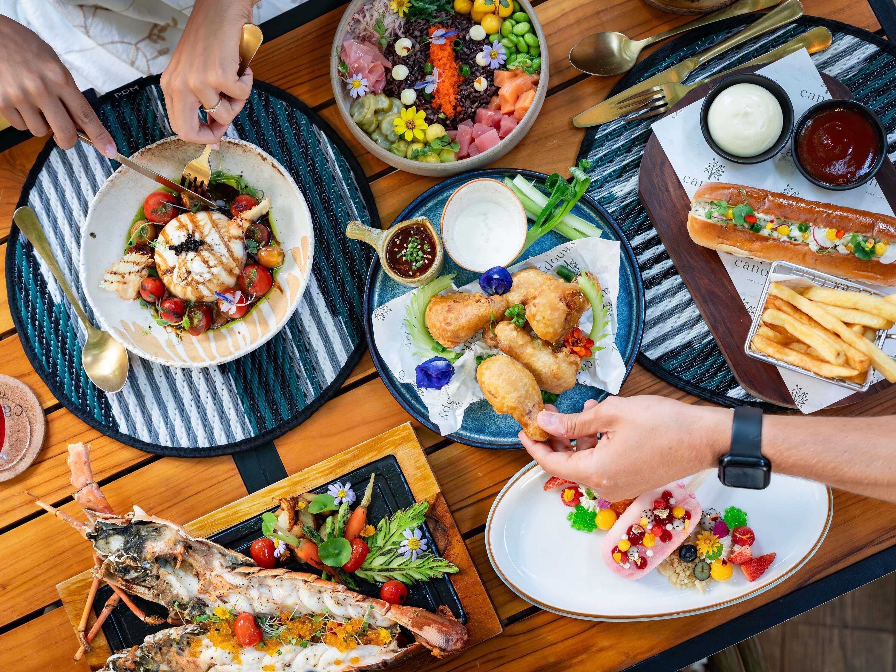 A dining table with various dishes, including seafood, vegetables, and bread.
