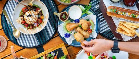 A dining table with various dishes, including seafood, vegetables, and bread.