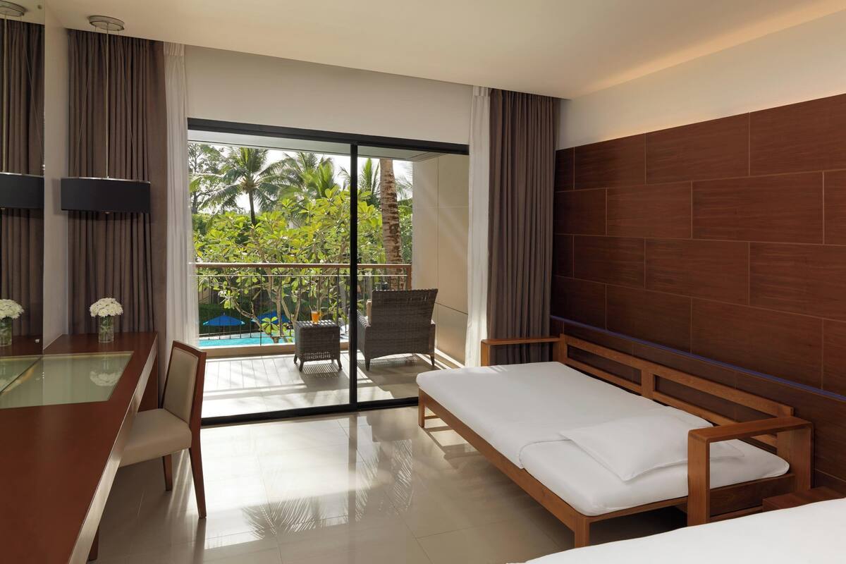 deluxe room, balcony, pool view (1 king bed and 1 sofabed) | living area | 42-inch lcd tv with satellite channels, tv, table football