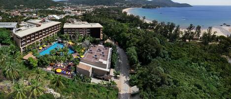 Hotel amb piscina, envoltat de vegetació exuberante i vistes a la platja i l'oceà.