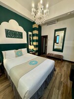 Ein Schlafzimmer mit einem großen Bett, einer Chandelier, einem Spiegel und einer dekorativen Wandverkleidung.