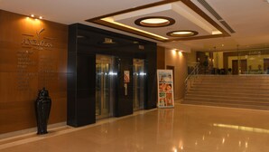 A hotel lobby with a reception desk, a black vase, and a staircase leading to another floor. - Anemon Hotel Malatya (Malatya)