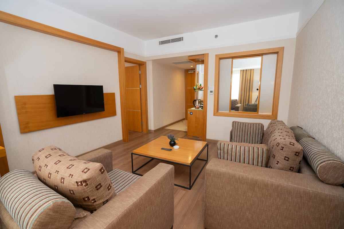 Junior Suite, 1 King Bed | Living area | 32-inch LCD TV with satellite channels, TV