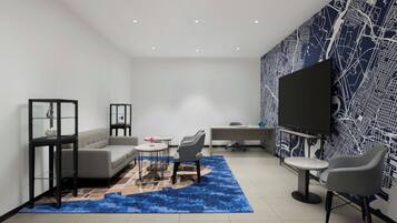 Una sala de estar moderna con un sofá, sillas, una mesa de centro, un televisor y una pared con diseño.
