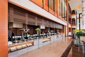 Relax in our spacious lobby, featuring a long reception area with glass display cases and comfortable seating areas.