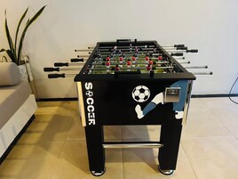 Una mesa de futbolín con un logotipo de balón de fútbol y la palabra 'SOCCER' en el lateral.