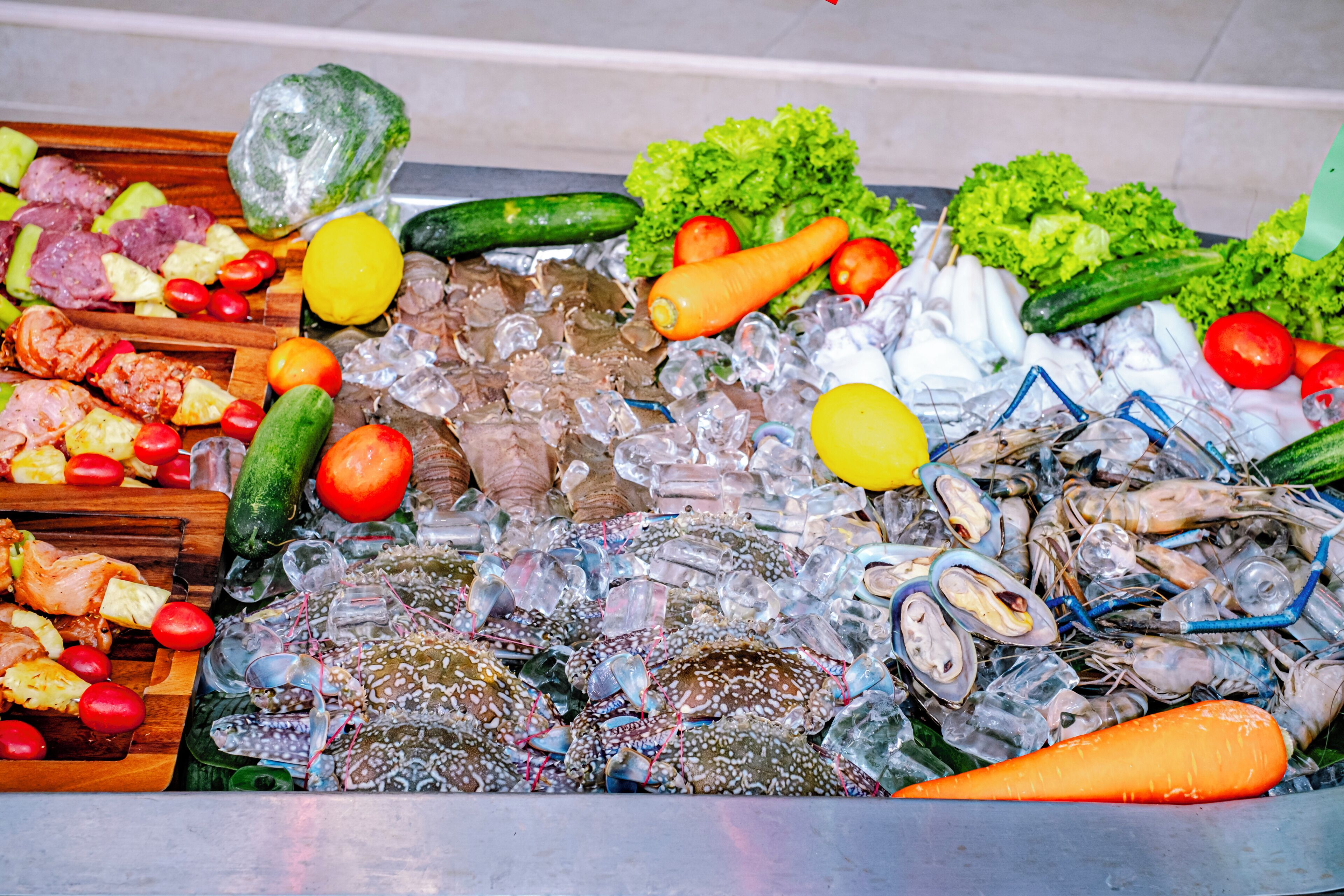 Diversidade de mariscos e vegetais expostos em um mercado.
