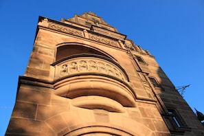 A stone tower with intricate carvings and a clock. - Hotel Deutscher Kaiser (Nuremberg)