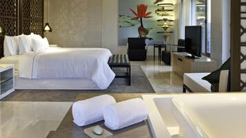 Una habitación de hotel moderna con una cama grande, un escritorio, una silla, un televisor y una bañera.