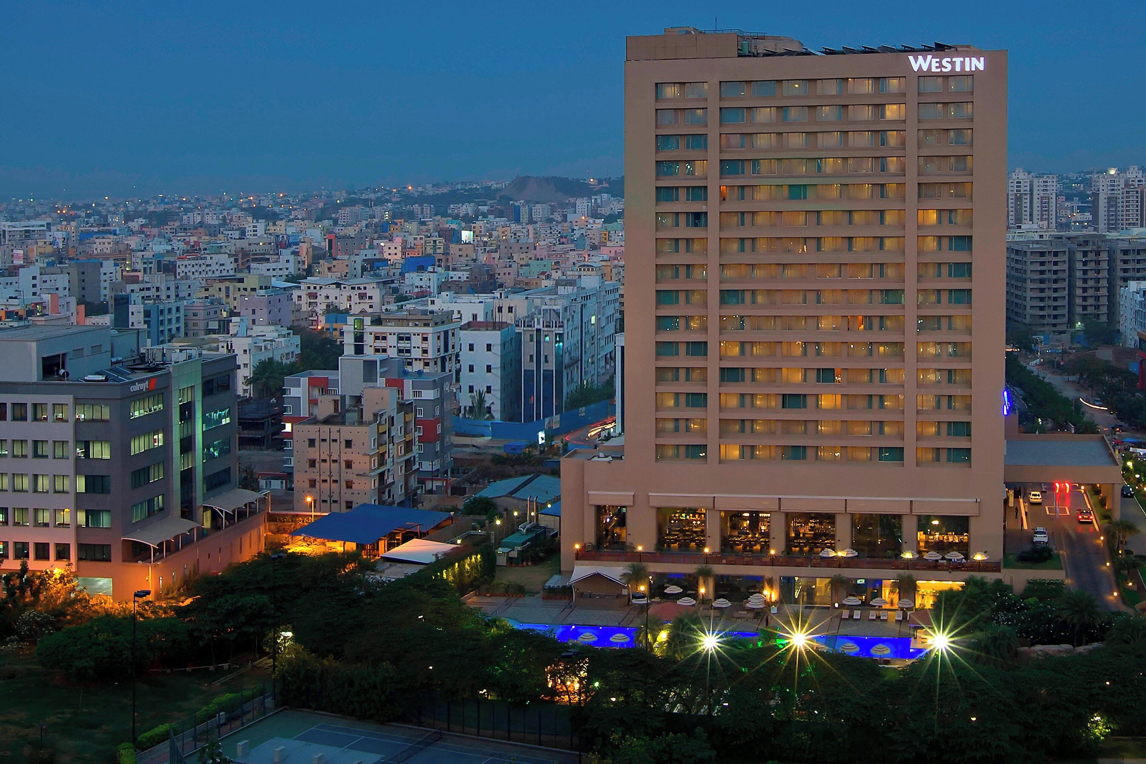 A Westin hotel with multiple floors, a rooftop pool, and a cityscape view.