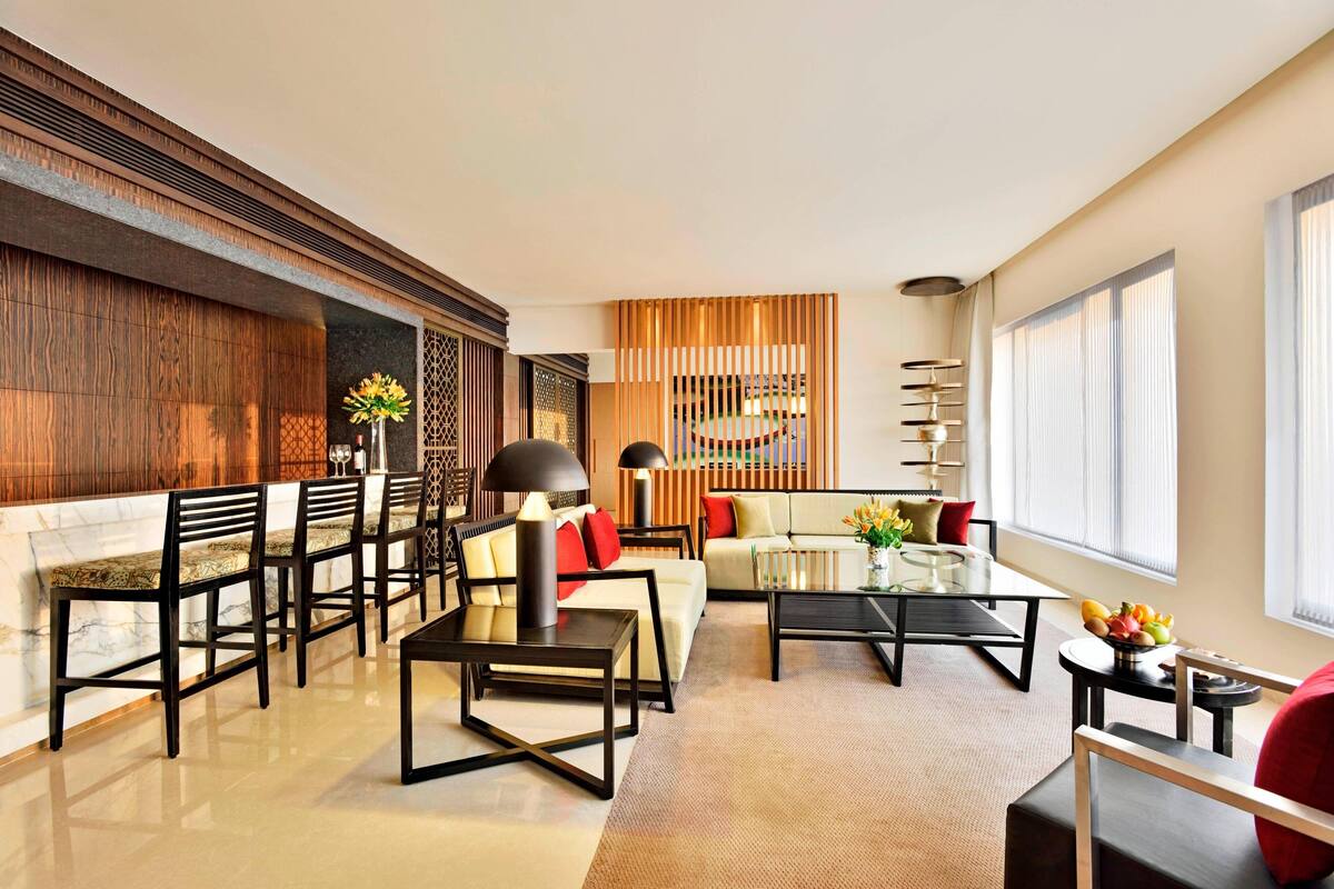 Un salon moderne comprenant un canapé, des fauteuils, une table basse et un coin repas.