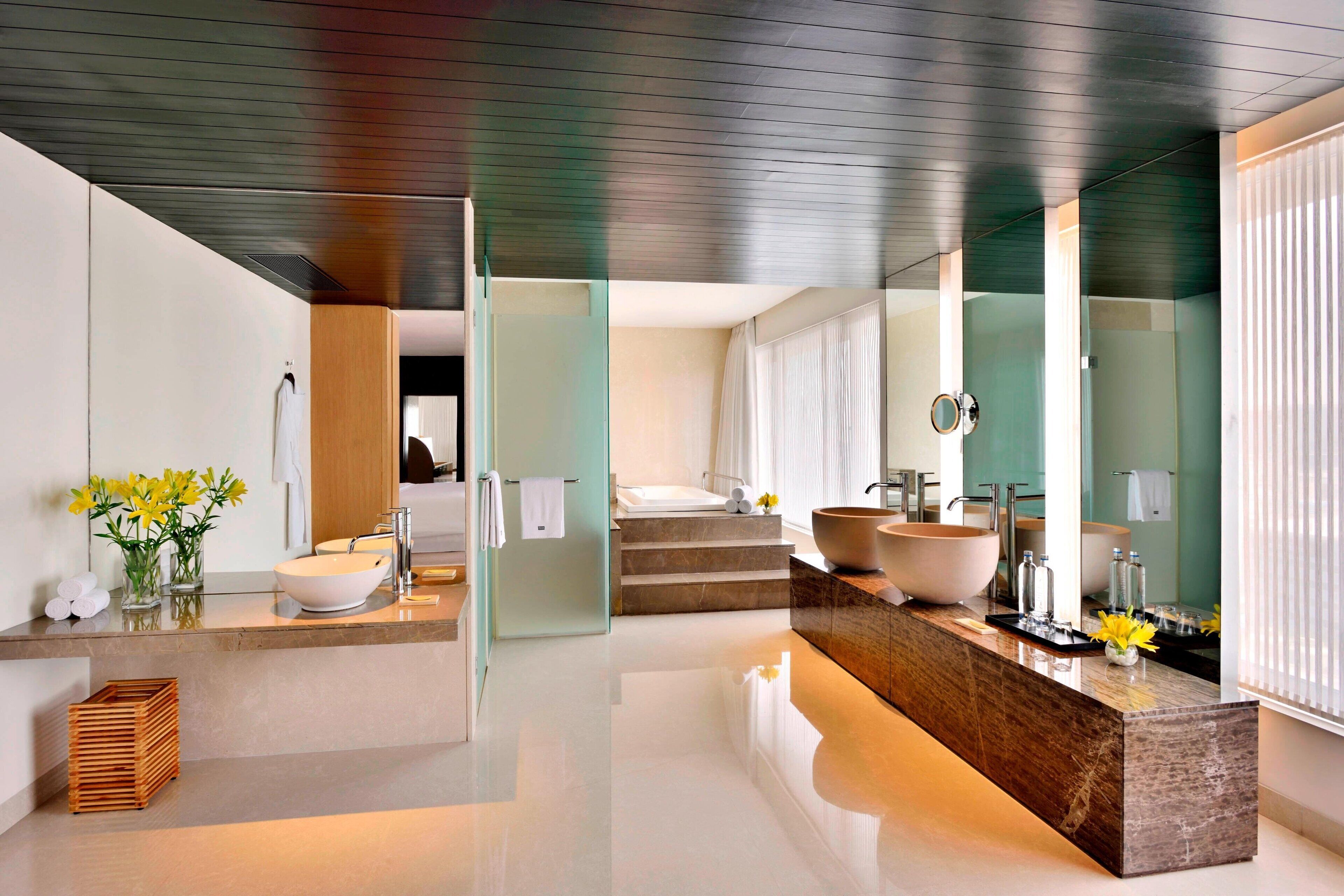 A modern bathroom with a large vessel sink, a separate basin, and a walk-in shower.
