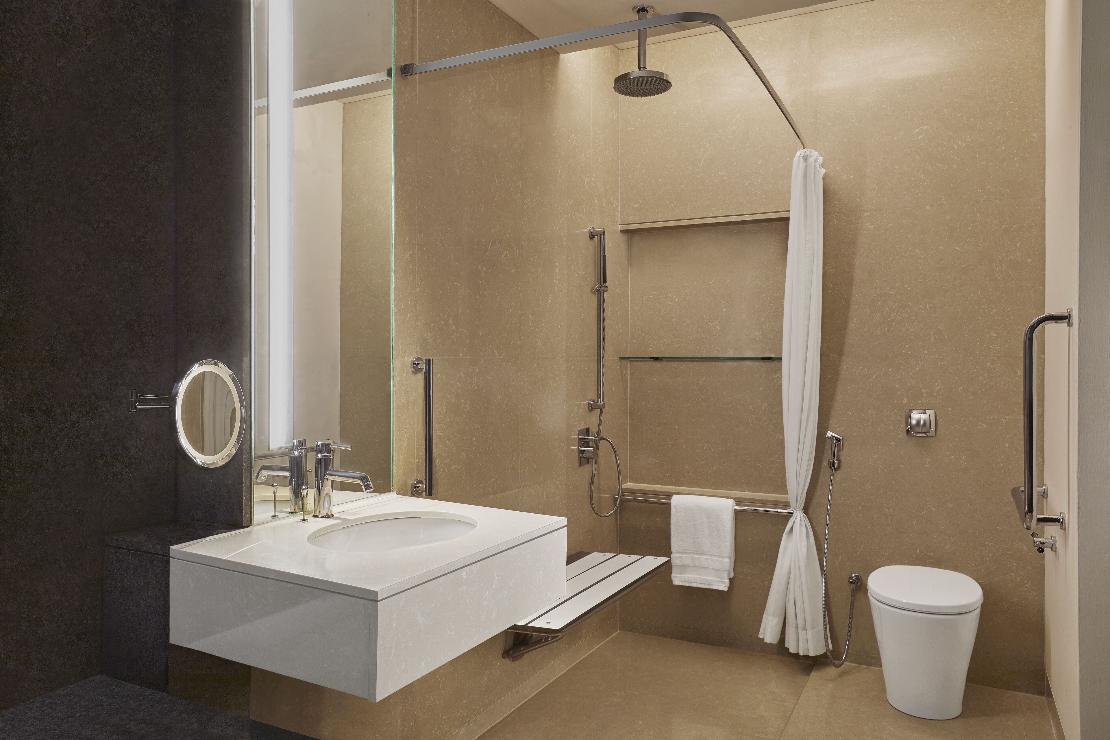 A modern bathroom with a large sink, a shower, and a toilet.