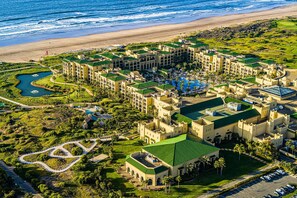 A resort with multiple buildings, a swimming pool, and a golf course.