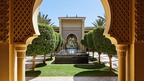 A courtyard with a fountain, surrounded by symmetrical trees and a patterned archway. - Mazagan Beach & Golf Resort (El Jadida)