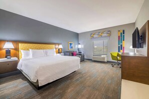 Relax in comfort with a large bed, flat-screen TV, and desk area.