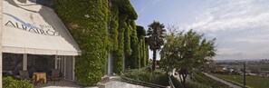 Un hotel llamado 'Hotel Albatros' con una zona de estar exterior cubierta y vistas a la ciudad.