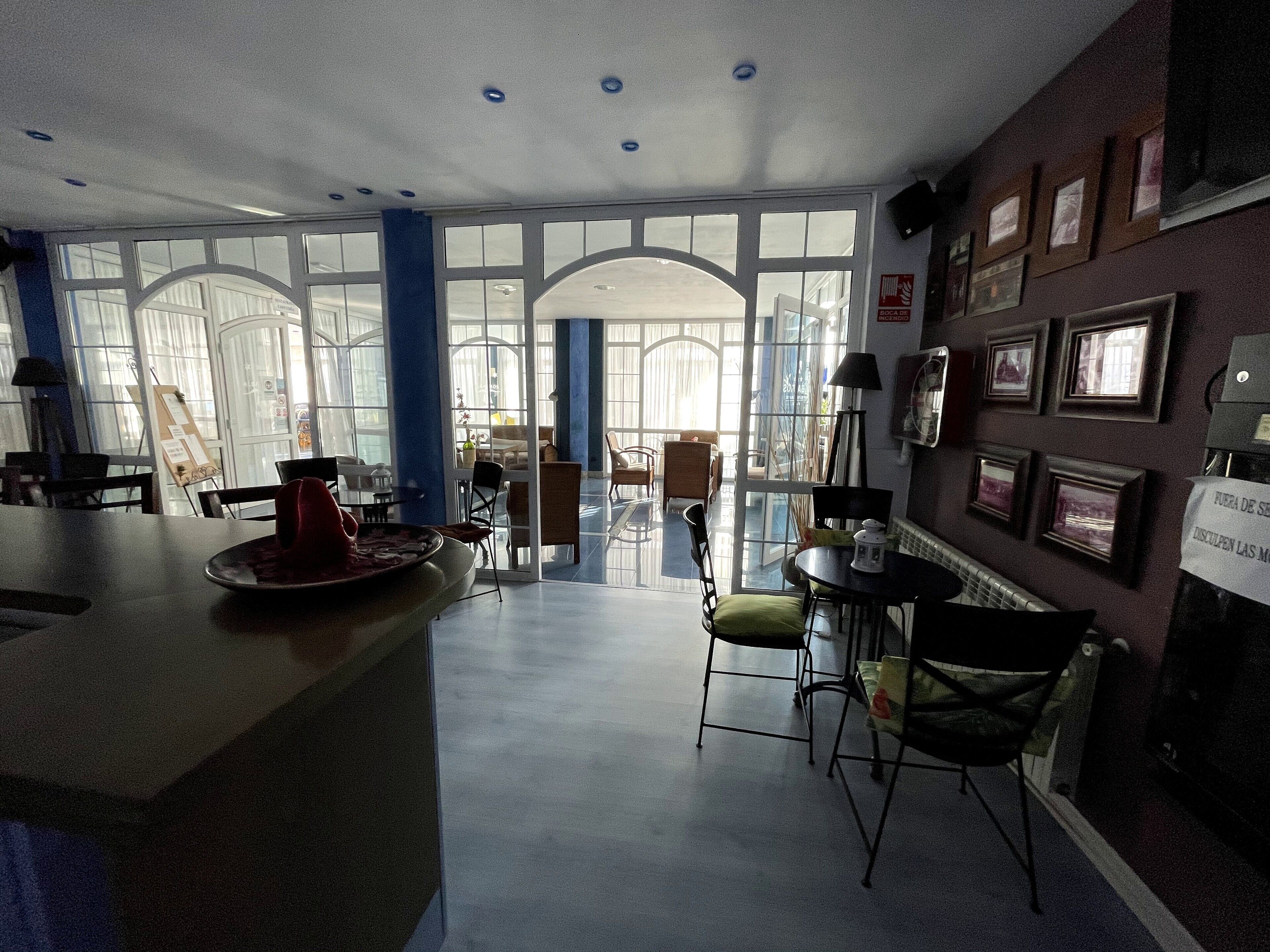 Una habitación amplia con un ventanal grande, una zona de bar y una disposición de asientos.