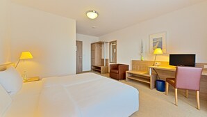 A hotel room with a bed, desk, chair, TV, and wardrobe. - St. Fridolin (Bad Saeckingen)