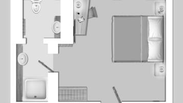 A bedroom with a bed, bedside table, and a window.