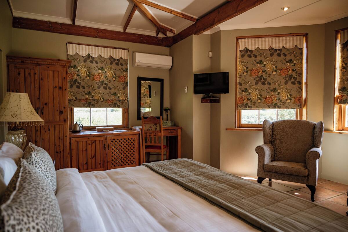 Un dormitorio con cama, escritorio, silla y televisor.