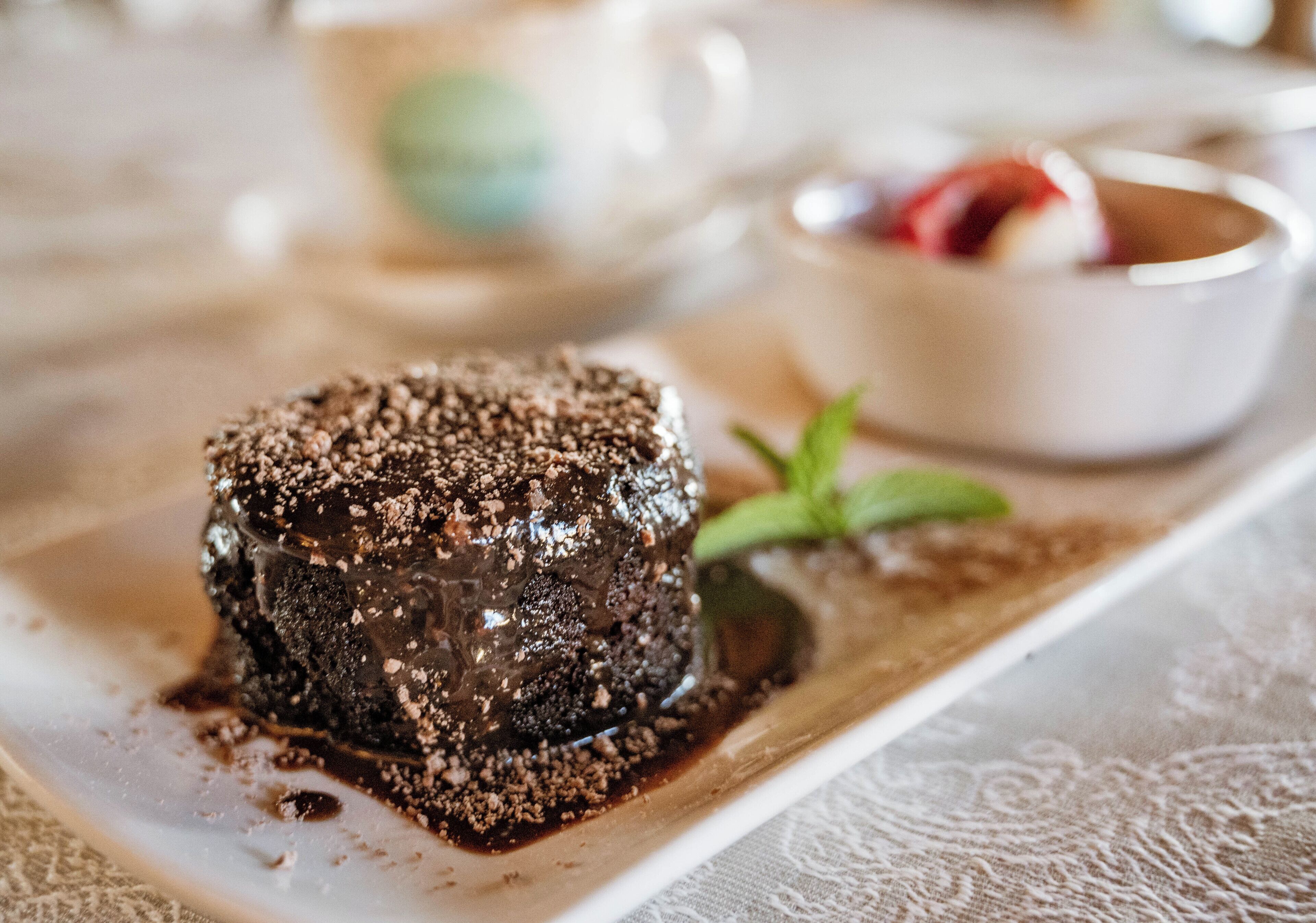 A dessert on a white plate with a mint leaf garnish.