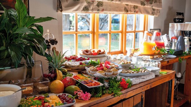 A breakfast buffet with a variety of fruits, pastries, and beverages.