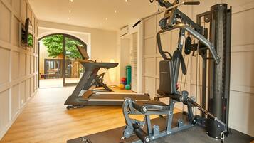 A gym with exercise equipment, a treadmill, and a mirror.