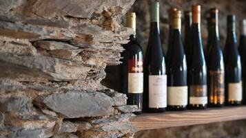 Un mur de pierres contre lequel sont alignées des bouteilles de vin.
