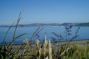 Paisagem costeira com vista para o mar e colinas ao longe.