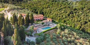 Un vaste domaine doté d’une piscine, entouré d’une forêt dense.