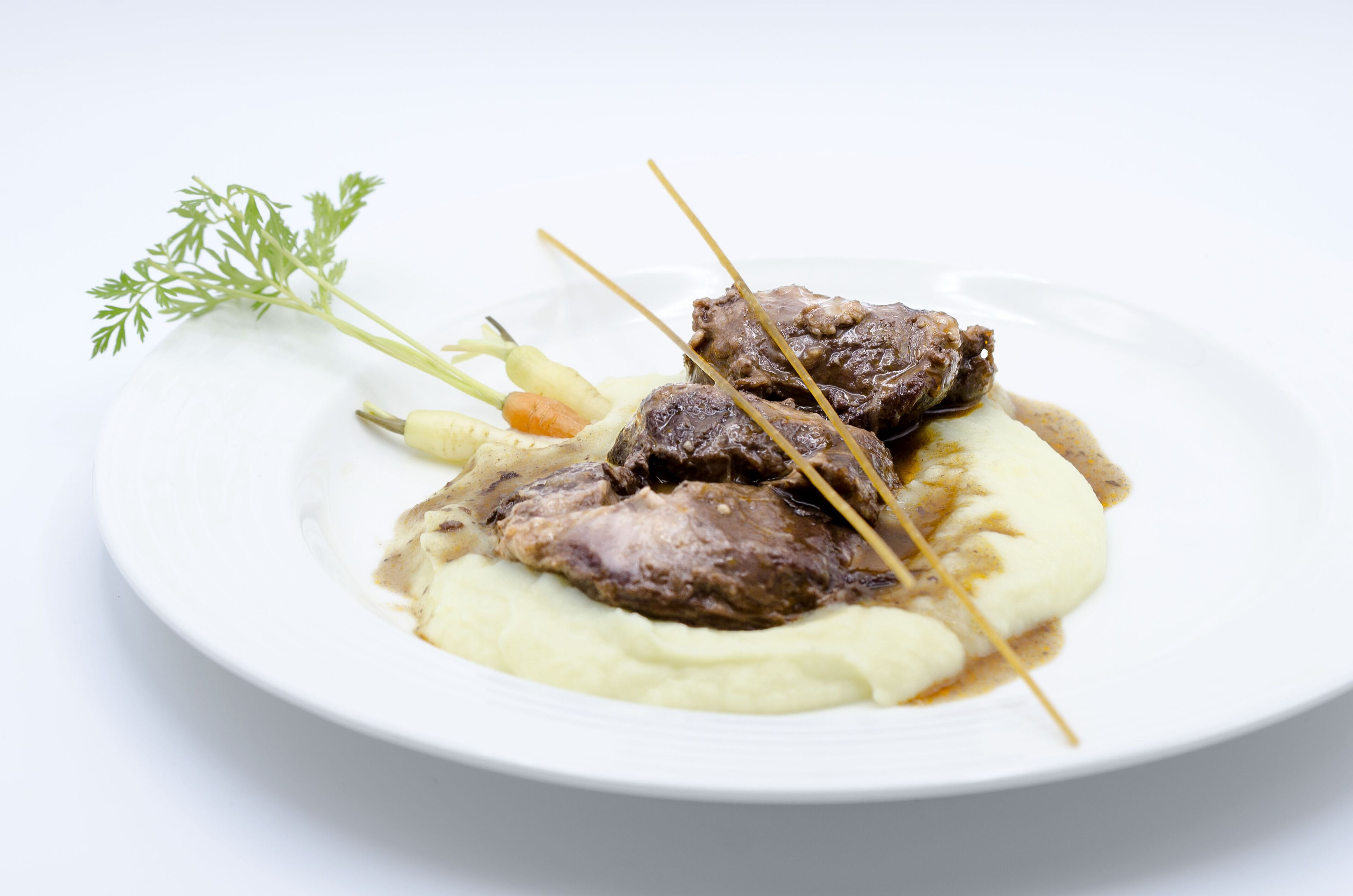 Un plato con carne, puré de papas y una guarnición.