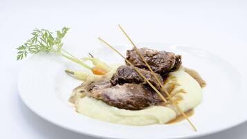 Un plato con carne, puré de papas y una guarnición.
