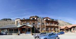 A resort building with a stone facade, wooden balconies, and a sign reading "Resort & Spa". - Arha Reserva del Saja (Valle de Cabuerniga)