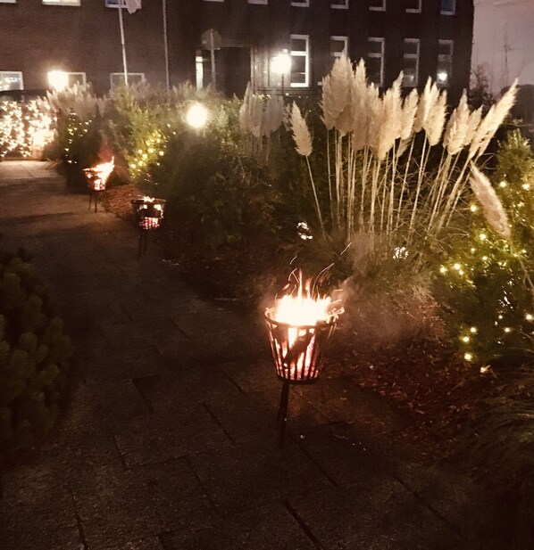 A pathway lined with decorative lights and plants, leading to a building with multiple windows. - Beans Parc Hotel Jade (Wilhelmshaven)